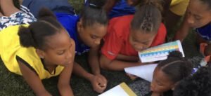 Niños leyendo al aire libre en la cancha
